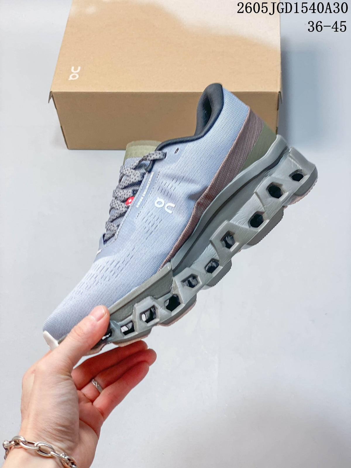 Side view of the pale gray sneaker and its sculpted sole with open sections