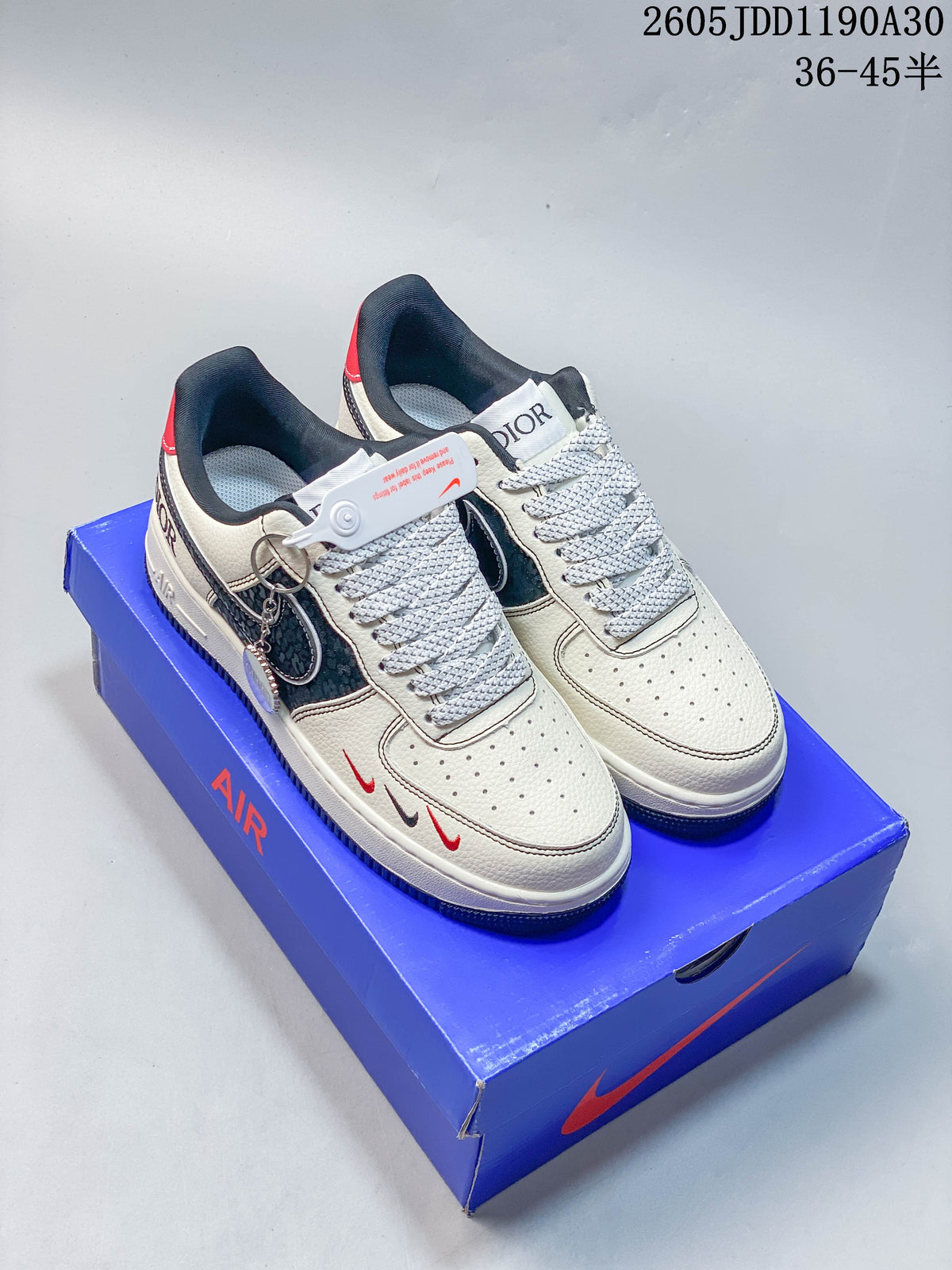 Pair of ivory and navy Nike Air Force 1 ’07 LV8 sneakers shown on a blue shoebox