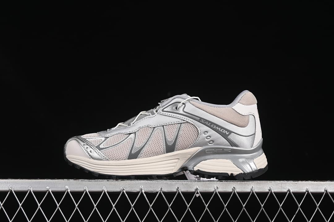 Side profile of silver and off-white Salomon XT-Whisper sneakers on a dark background.