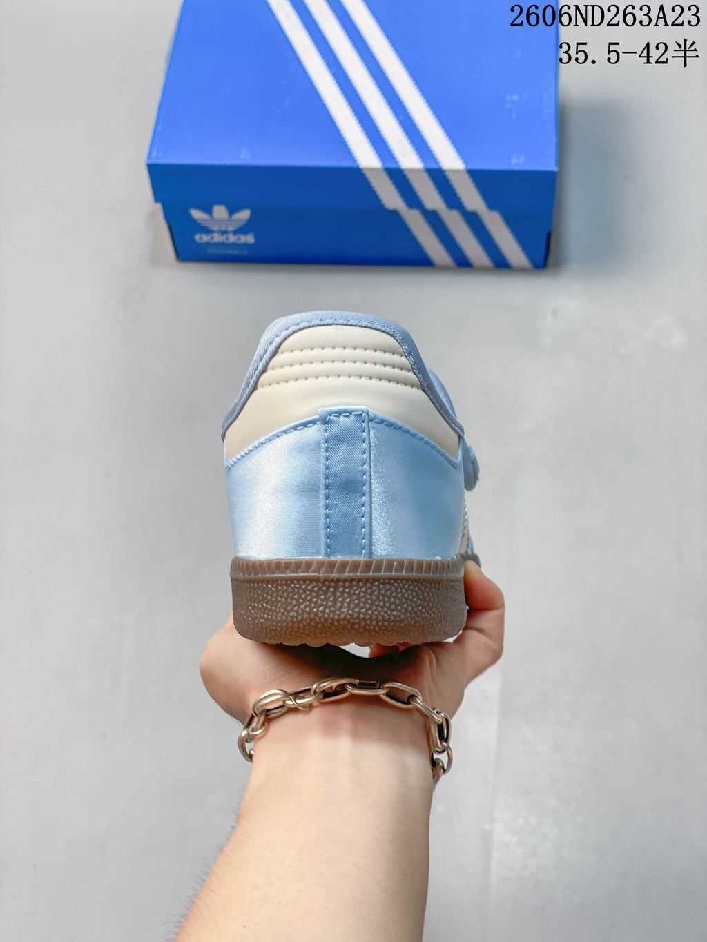 Rear view of a light blue Adidas Samba Jane sneaker with a brown outsole