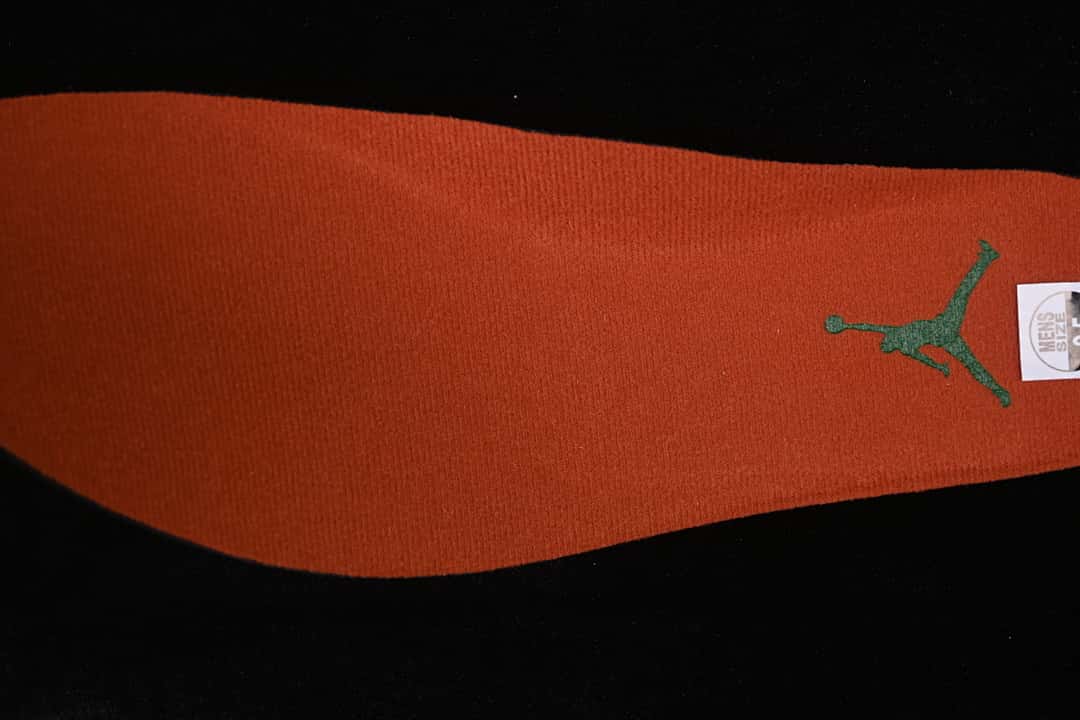 Orange insole with a green Jumpman-style graphic and a partially visible size label