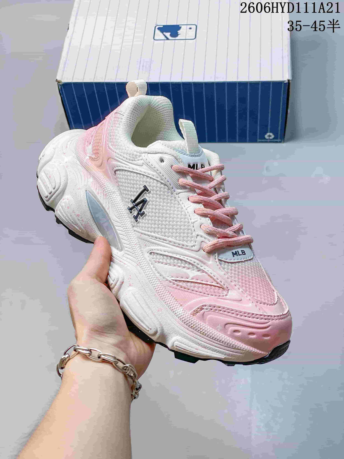Angled close-up of the white and pink sneaker with NY side graphics.