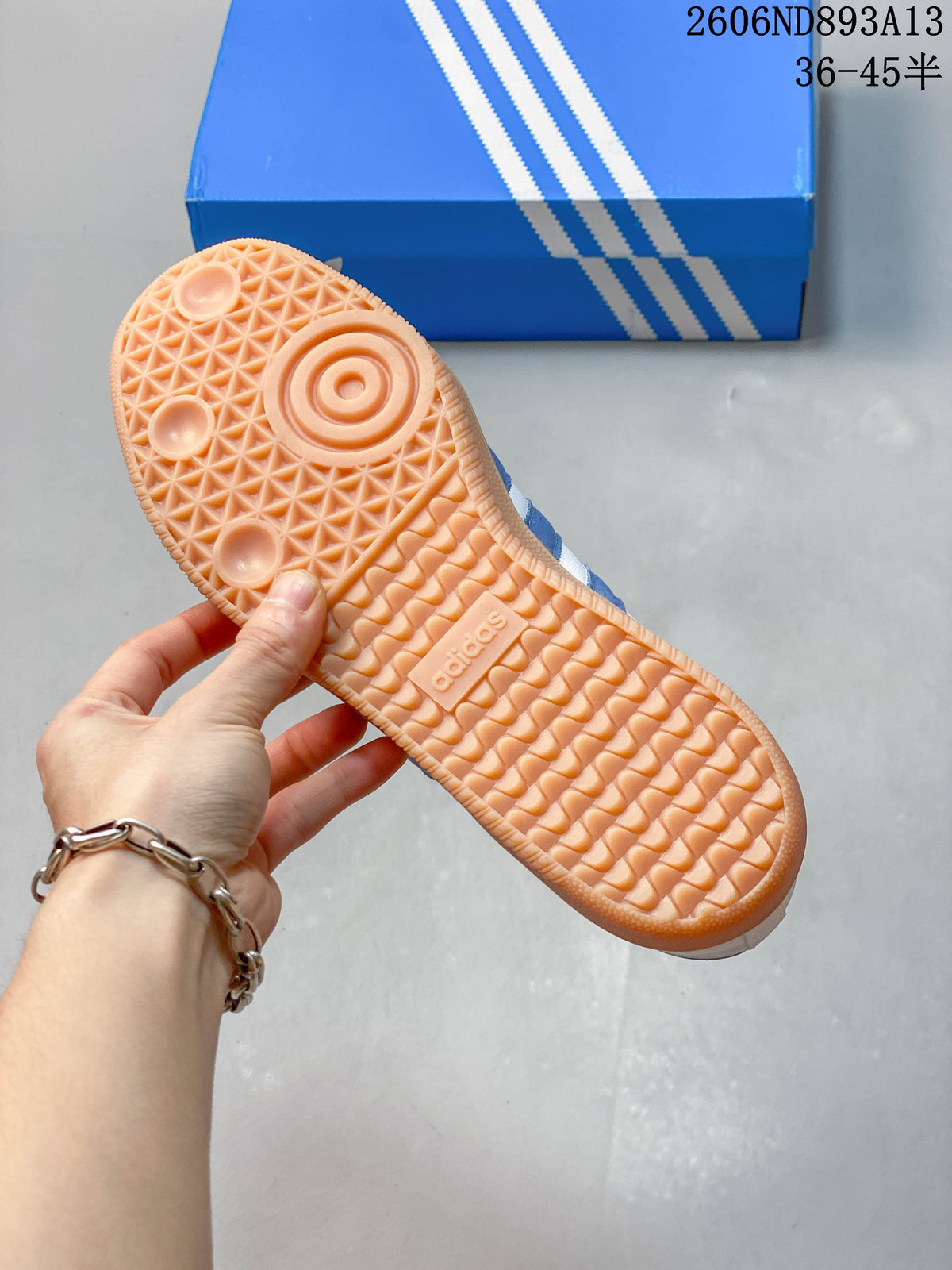Close view of the gum-colored outsole on the white and blue sneakers.