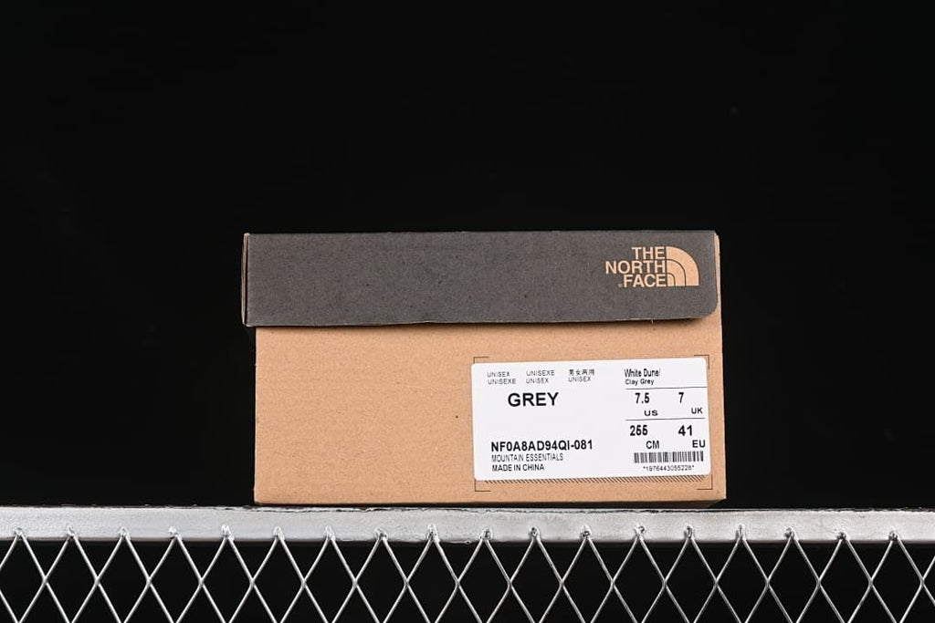 Shoebox label showing grey color, Mountain Essentials, style code NF0A8AD94QI-081, and a sample size of US 7.5, UK 7, EU 41, 265 cm.