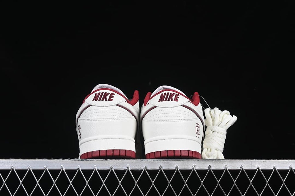 Rear view of both sneakers with Nike heel tabs and burgundy outsoles
