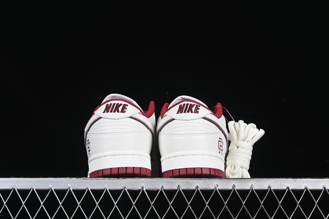 Rear view of both sneakers with Nike heel tabs and burgundy outsoles