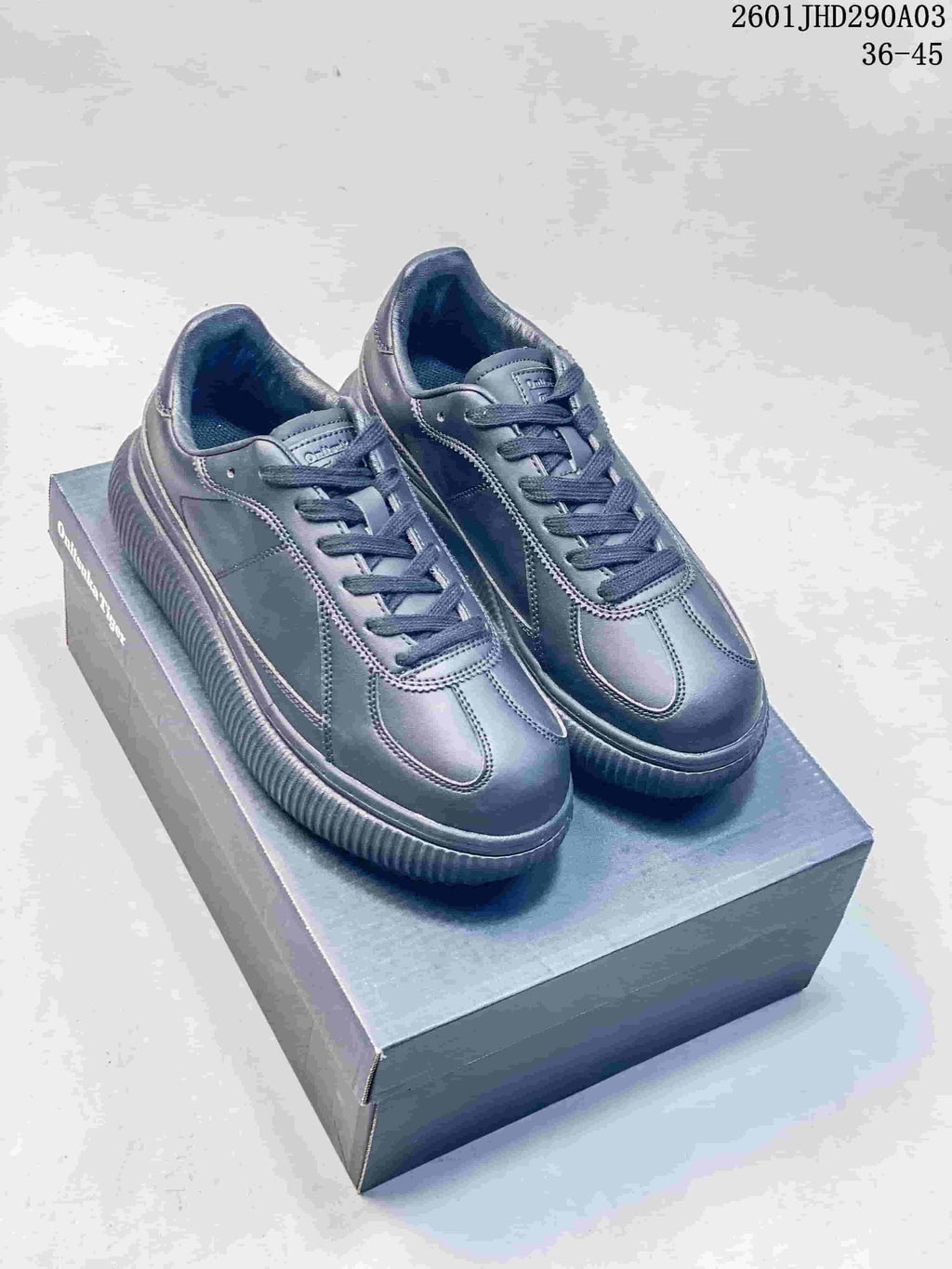 Pair of dark charcoal Onitsuka Tiger Delecity low-top sneakers displayed on a box