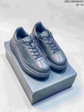 Pair of dark charcoal Onitsuka Tiger Delecity low-top sneakers displayed on a box