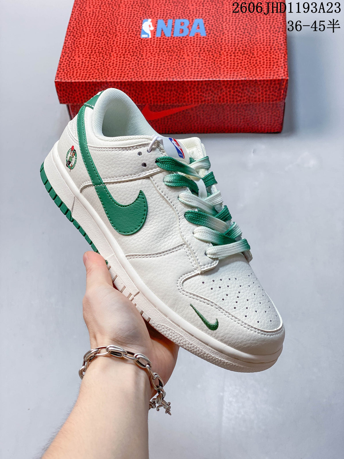 Angled side view of a white and green low-top sneaker with a Celtics-style emblem and NBA-branded box