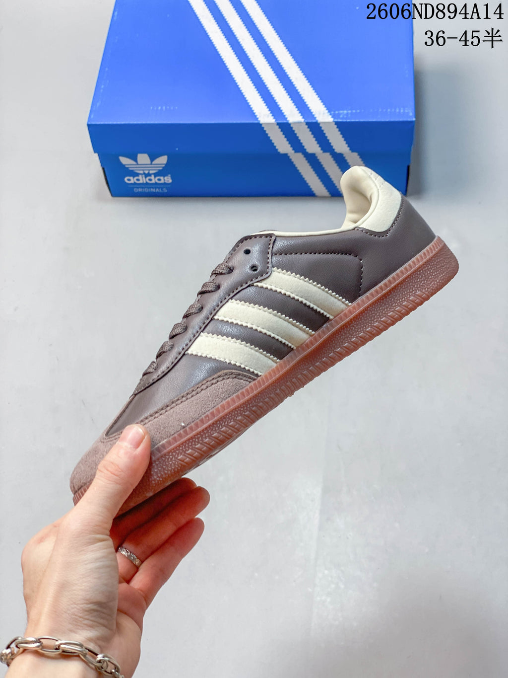 Side view of the brown and cream low-top sneaker with three stripes