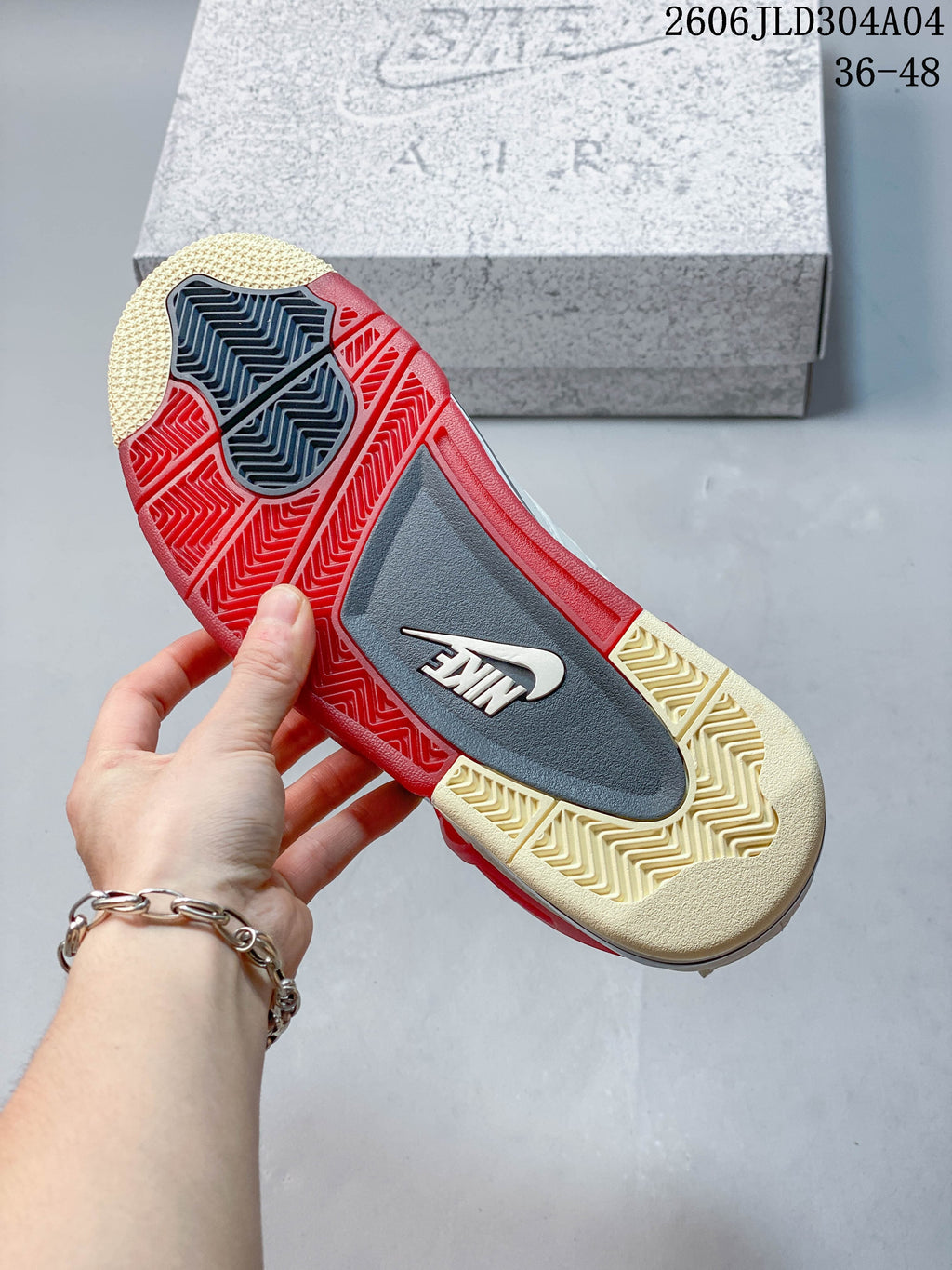Outsole of the sneaker showing red, grey and cream-colored sections