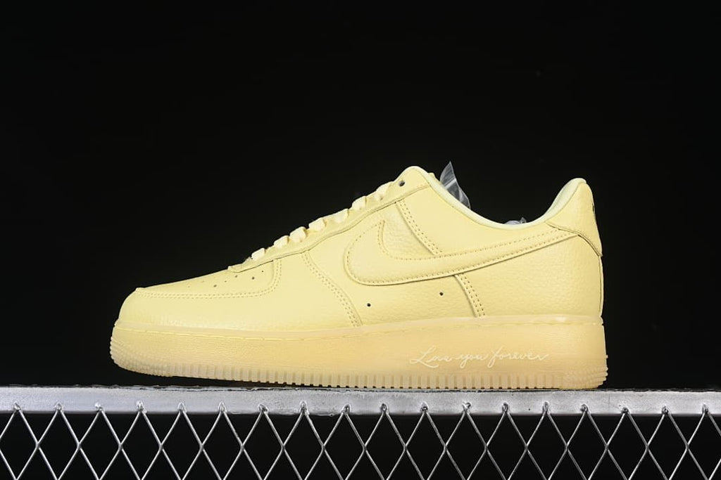 Side view of a pale yellow Nike Air Force 1 '07 Low sneaker with “Love you forever” midsole lettering
