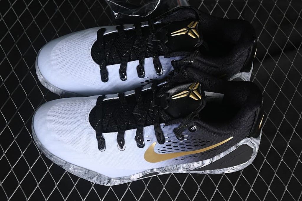 Pair of white, black, and gold low-top basketball shoes