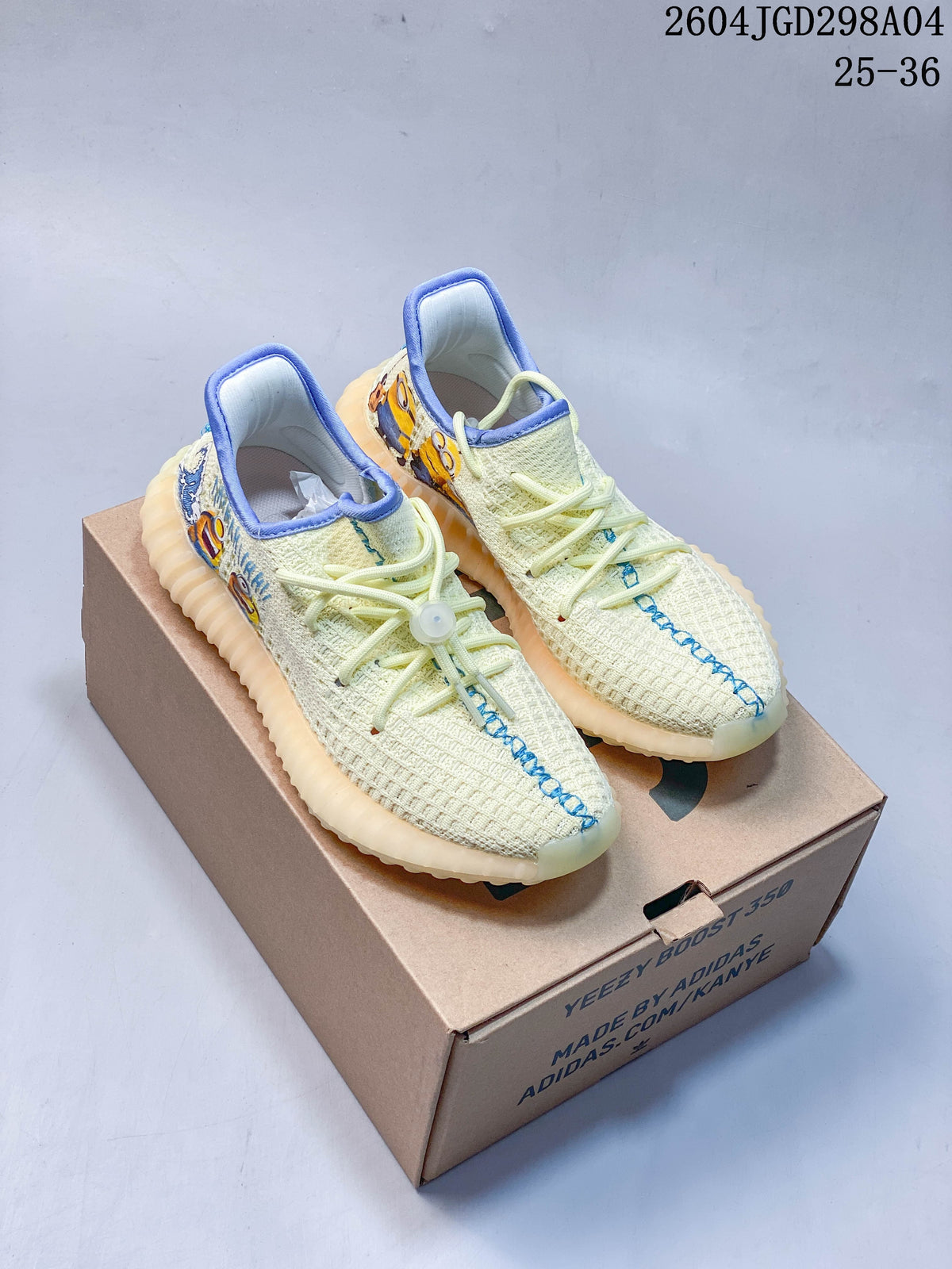 Pair of cream Adidas Yeezy 350 V2 kids sneakers with blue trim and colorful side graphics, shown on a shoe box