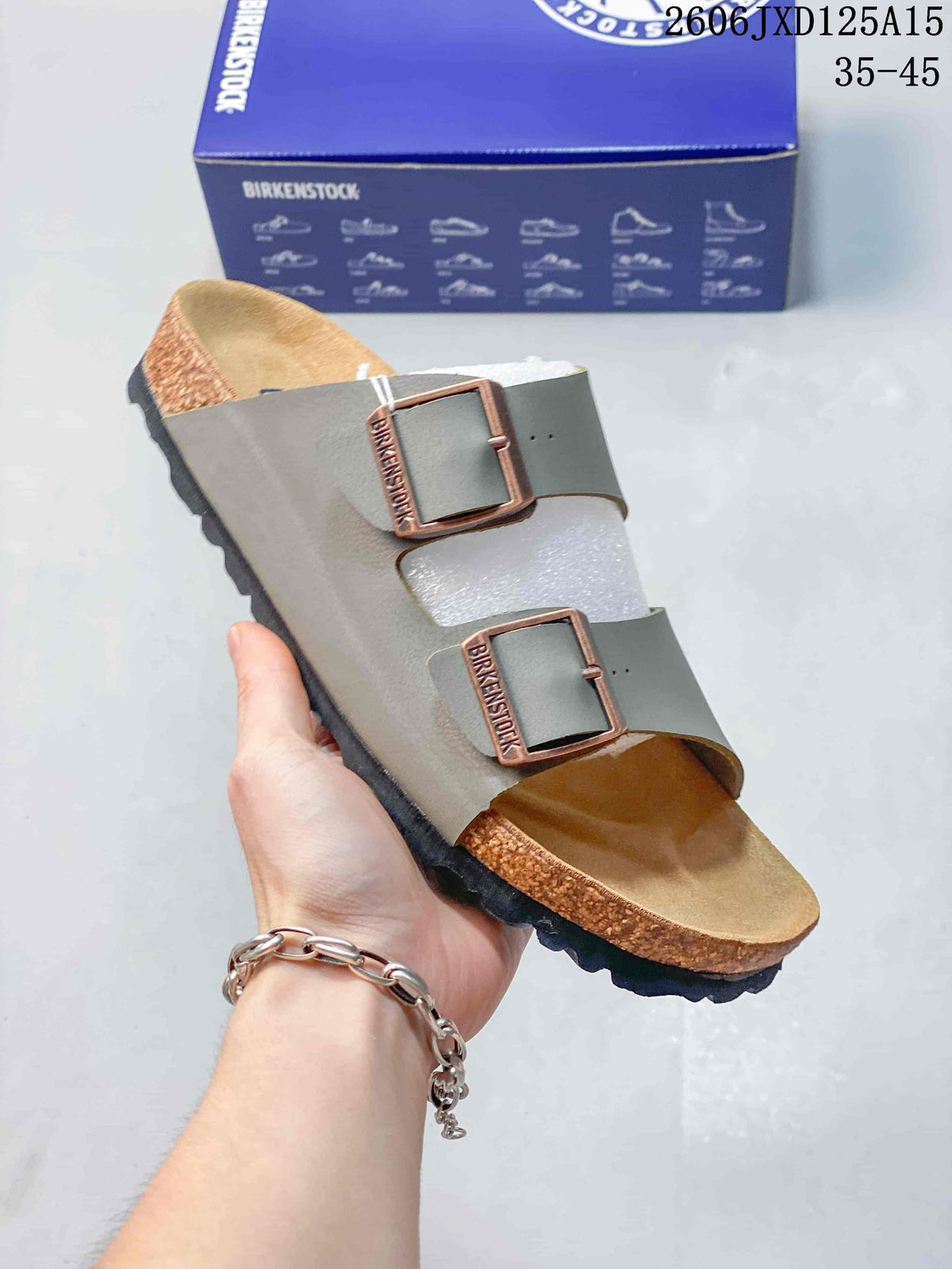 Angled view of a gray two-strap sandal with buckles and cork-look midsole