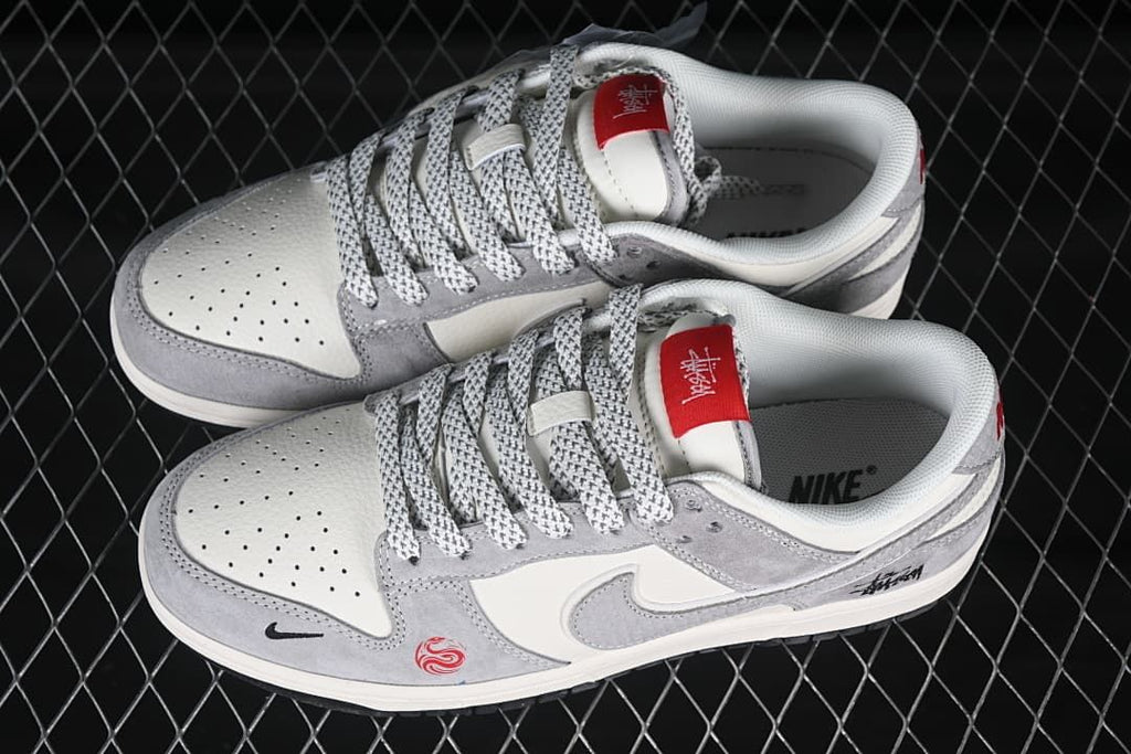 Top view of a pair of gray and off-white low-top sneakers with patterned laces