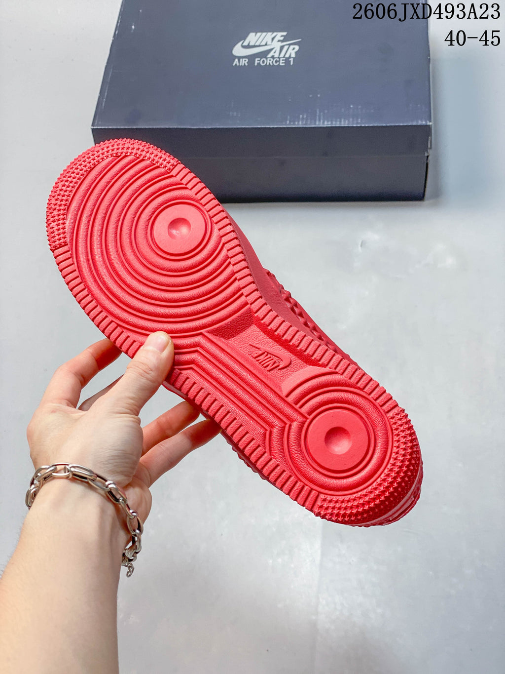 Underside of a red sneaker showing a circular-pattern rubber outsole