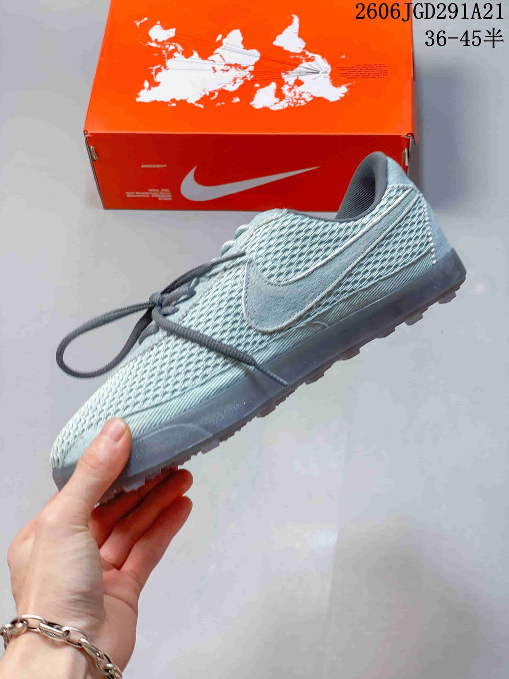 Side view of the pale blue-gray sneaker with textured upper and side Swoosh