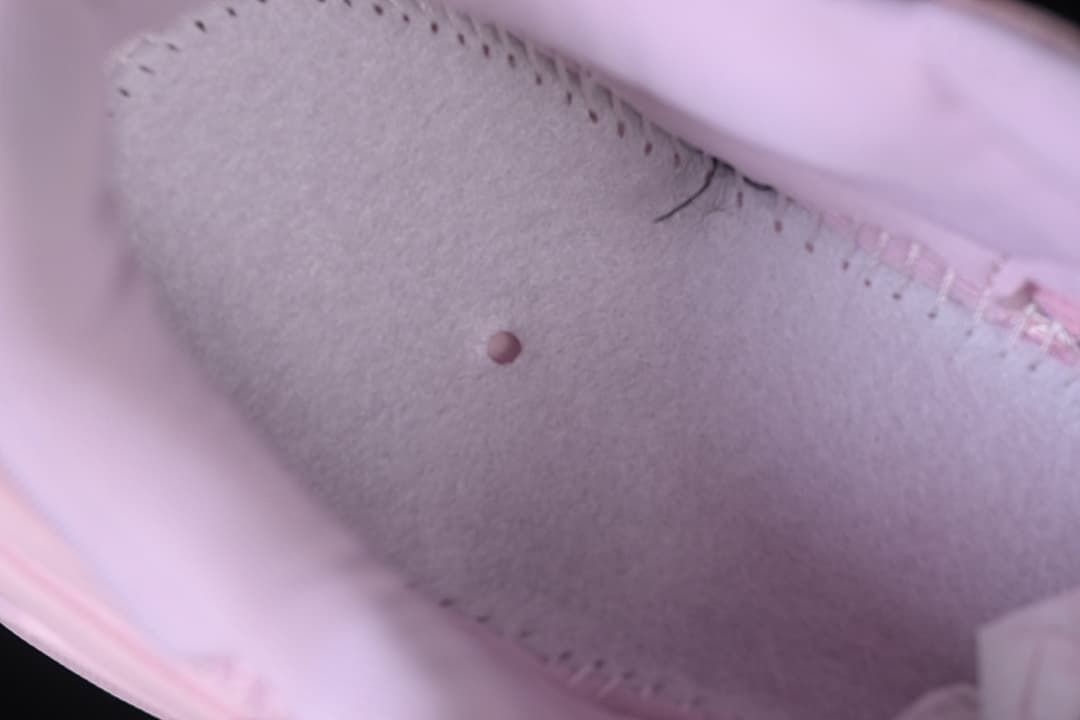 Close-up view inside the pink sneaker showing its lining and interior stitching.