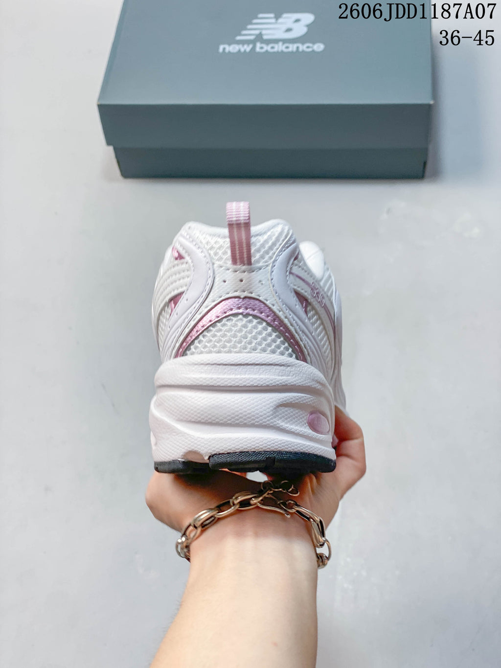 Rear view of a white and pink New Balance sneaker