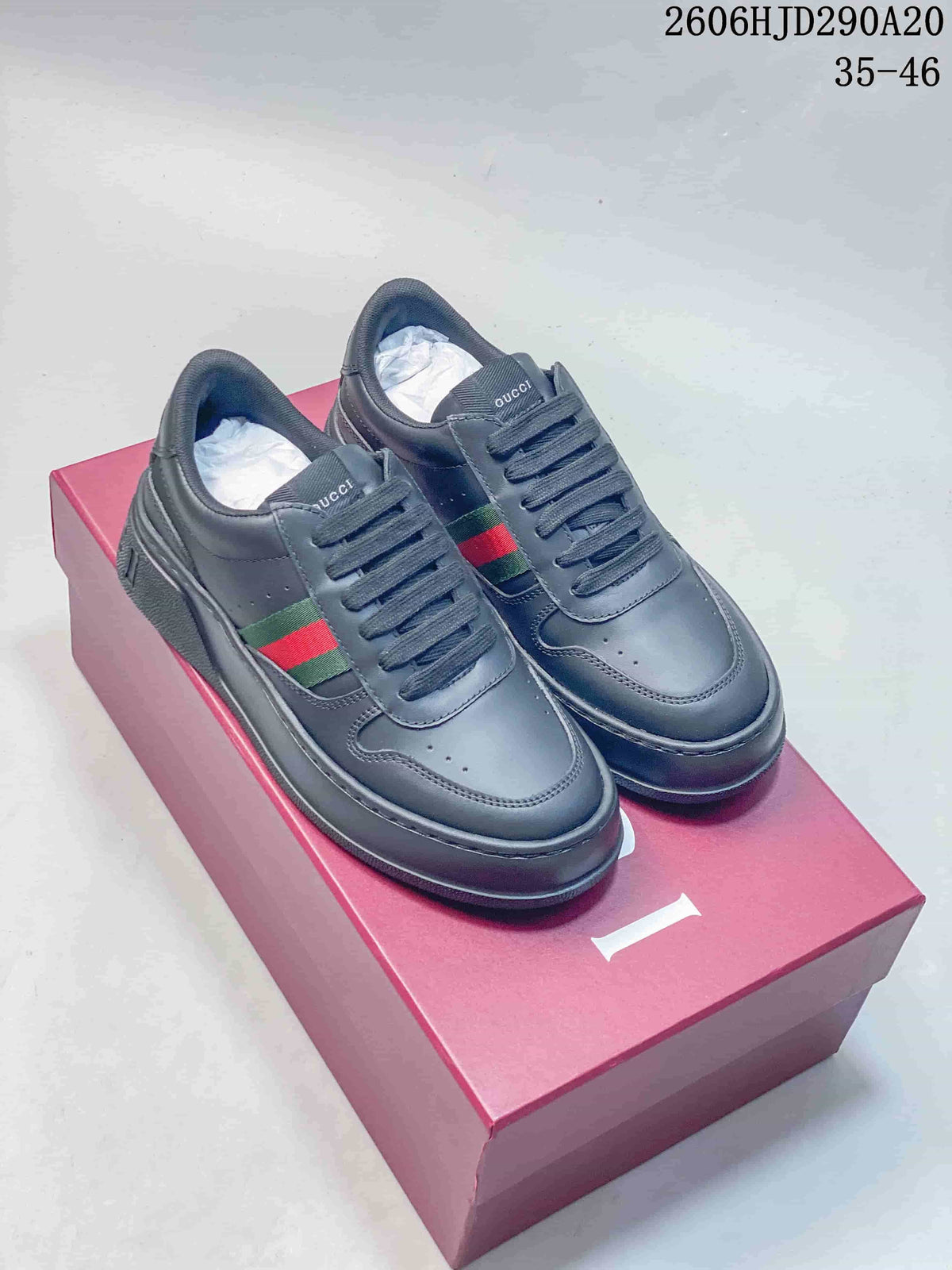 Pair of dark Gucci low-top lace-up sneakers with green-and-red side stripes and chunky soles