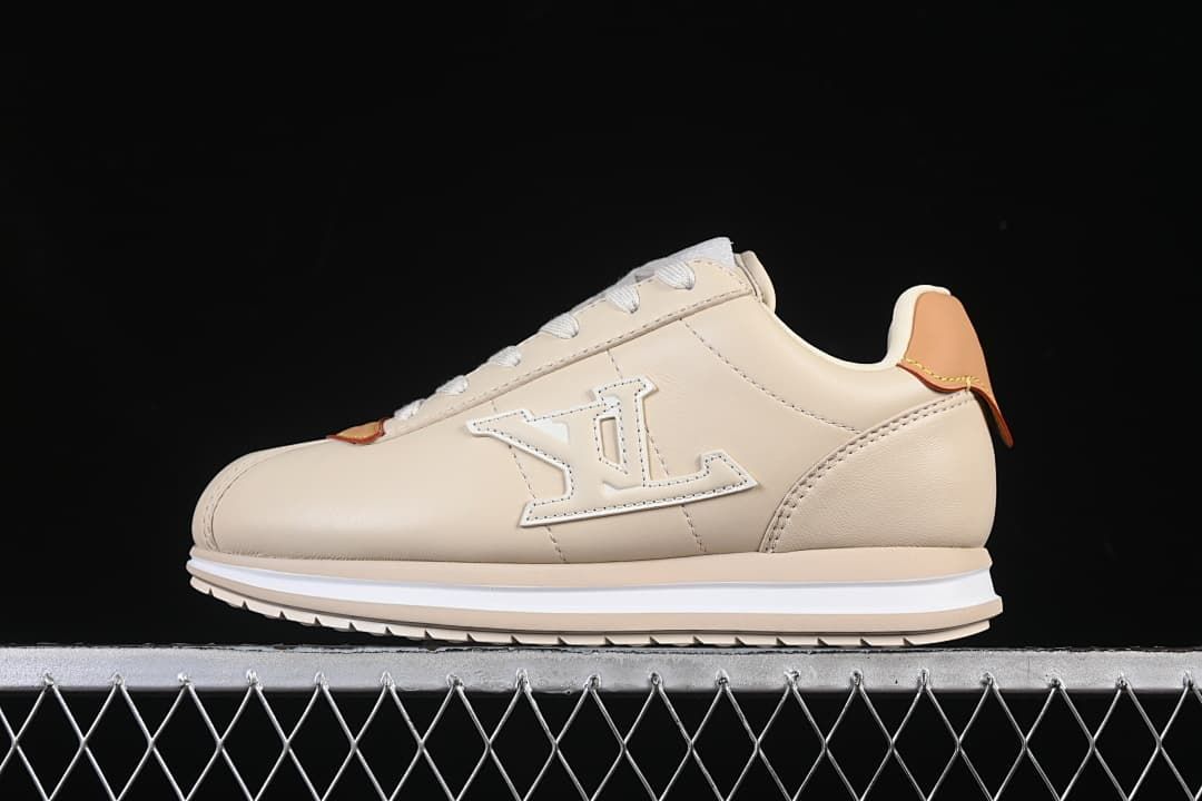 Side view of beige low-top sneaker with oversized side emblem