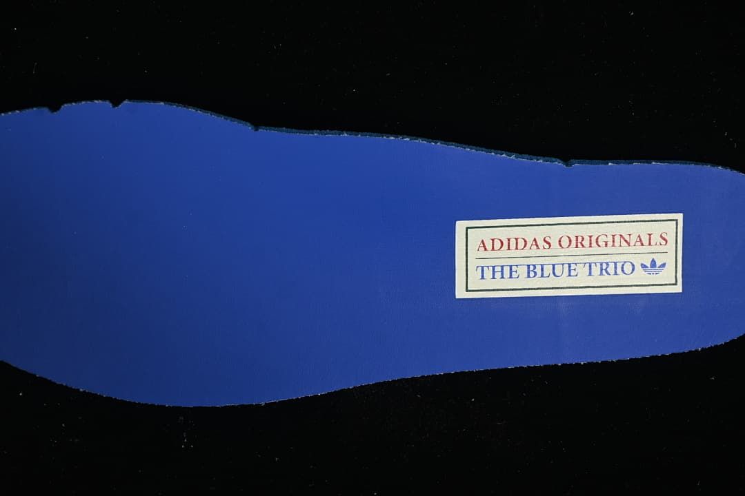 Blue shoe insert with a label reading adidas Originals The Blue Trio.