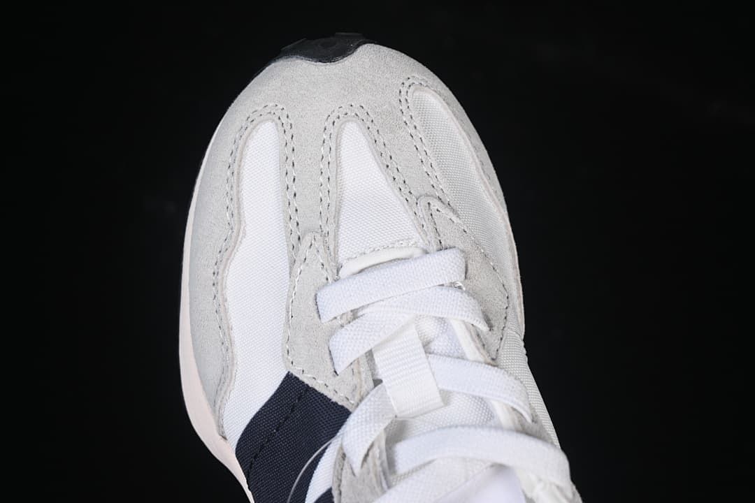 Top view of the sneaker’s toe, laces, and gray overlays.