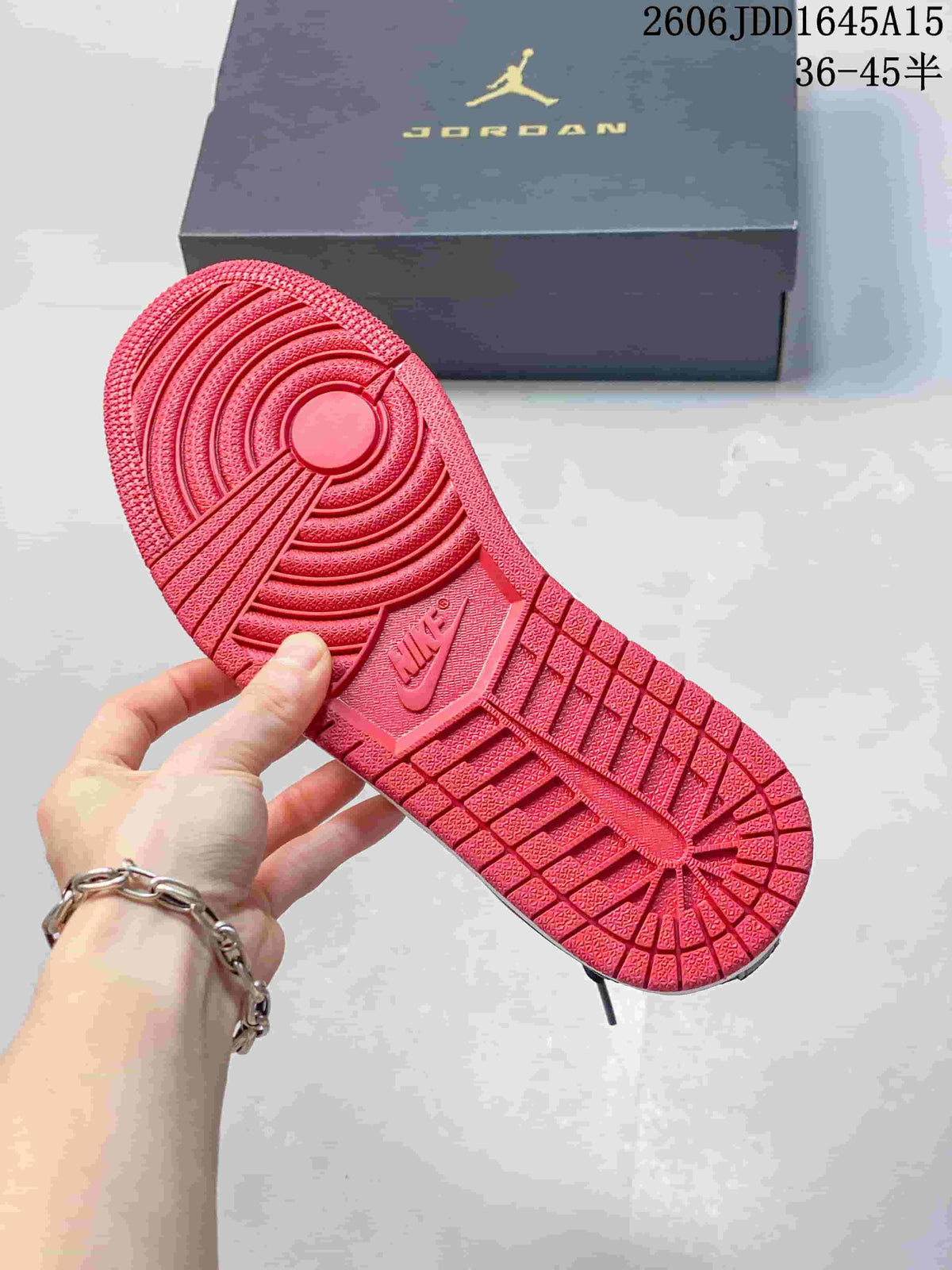 Red outsole with circular traction pattern on a Jordan Court Connect sneaker