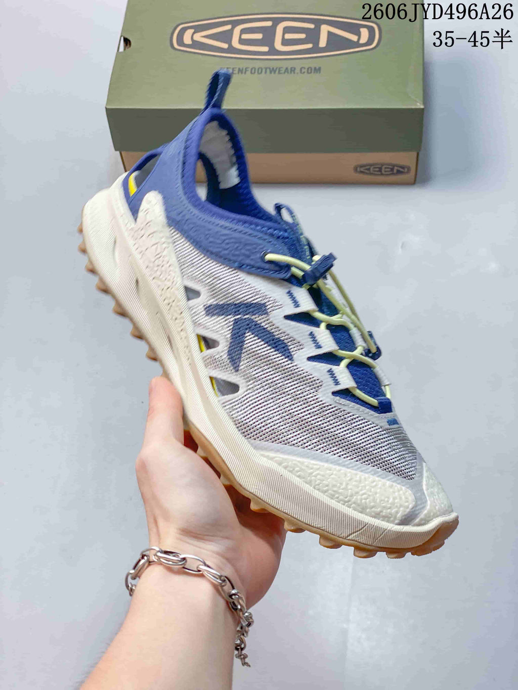 Side view of a white hiking shoe with blue accents and quick lacing