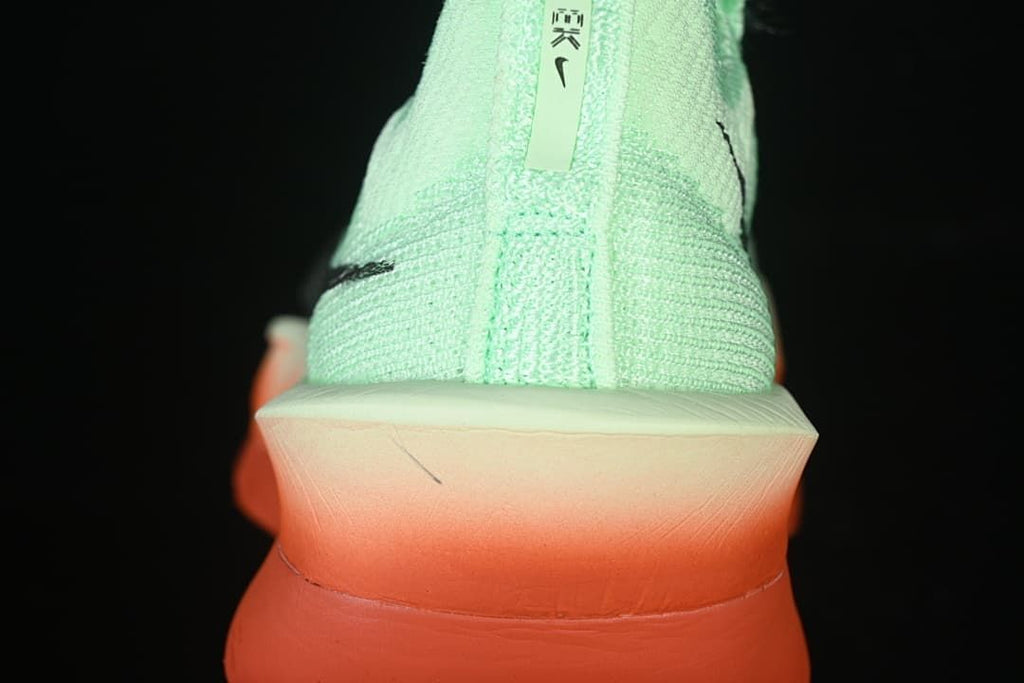 Rear view showing the mint-green heel and coral-orange sole.