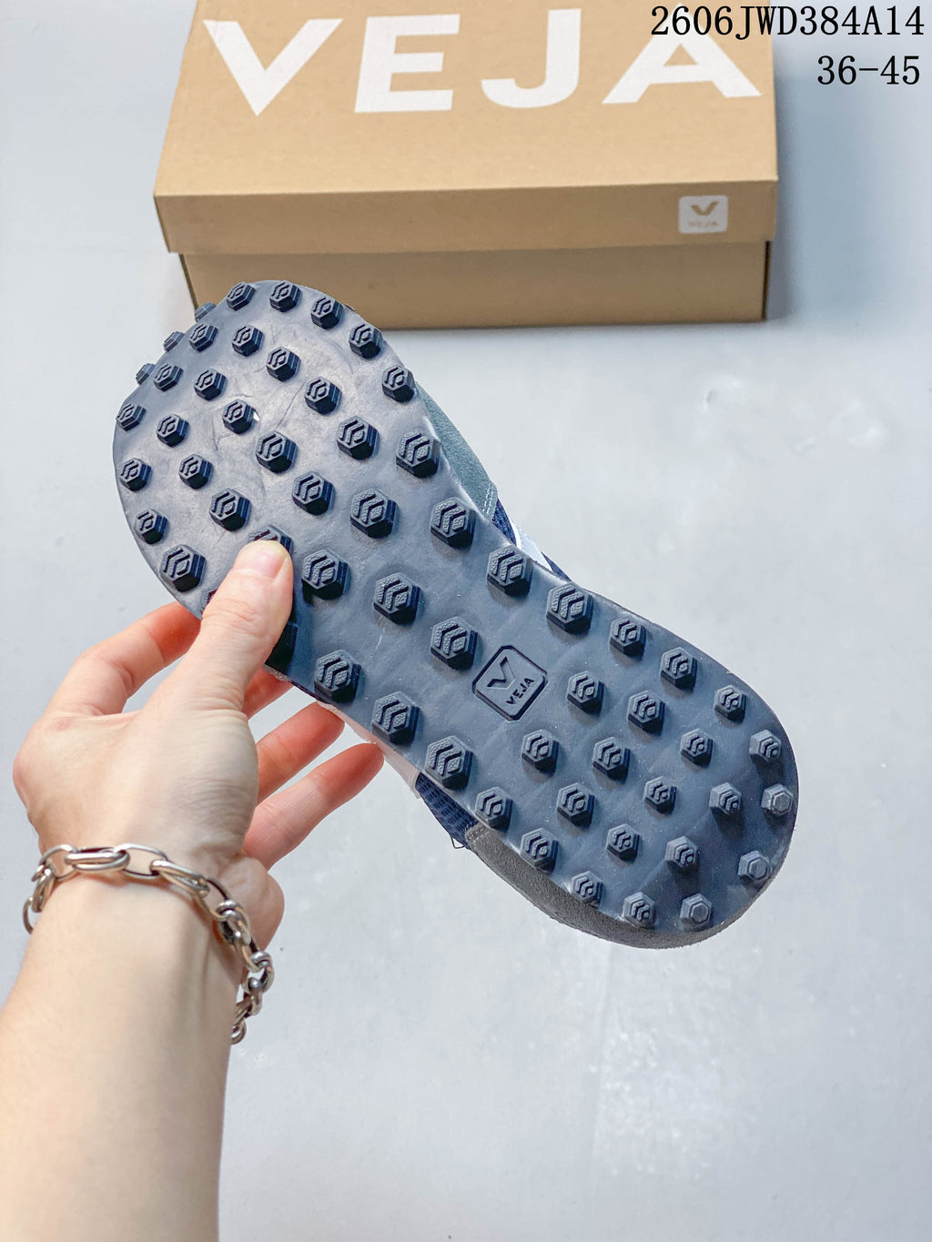 Close-up of the textured outsole on the navy and grey sneakers