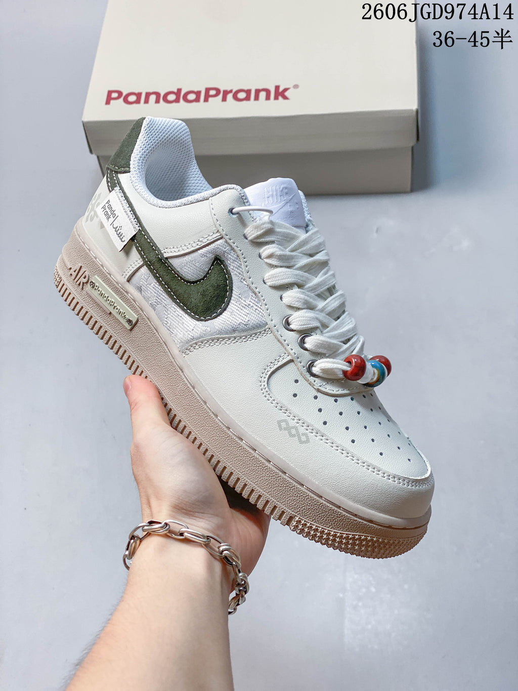 Angled side view of the white and dark green low-top sneaker