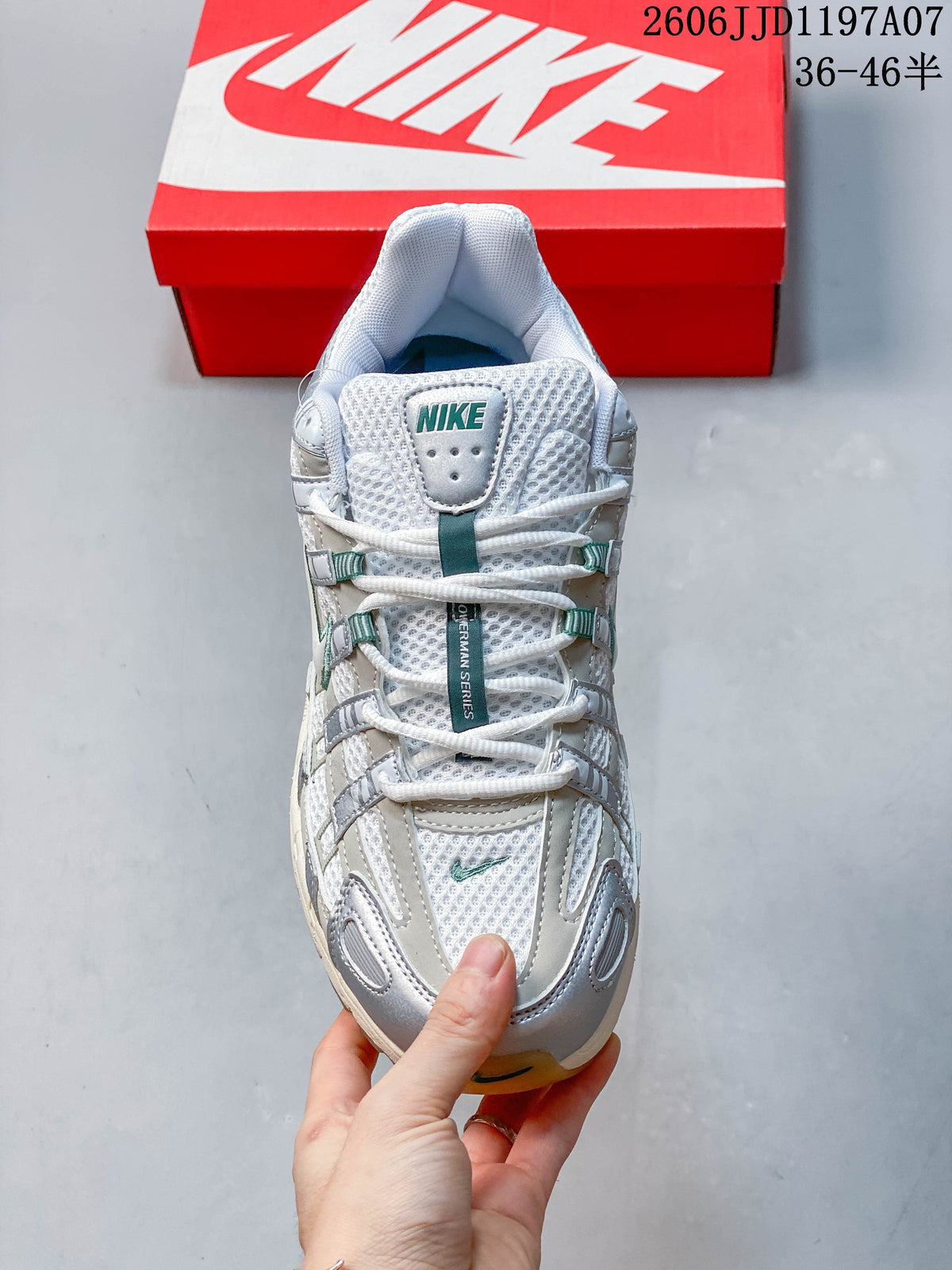 Front view of a white, silver, and teal lace-up sneaker