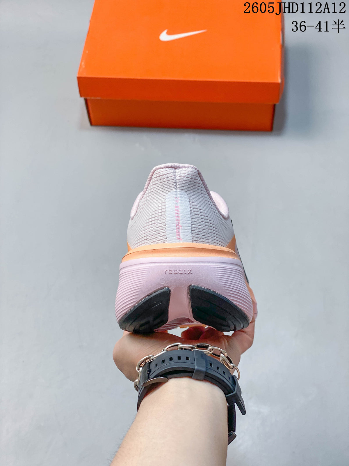 Rear view showing the heel and outsole of the white and pink running shoe.