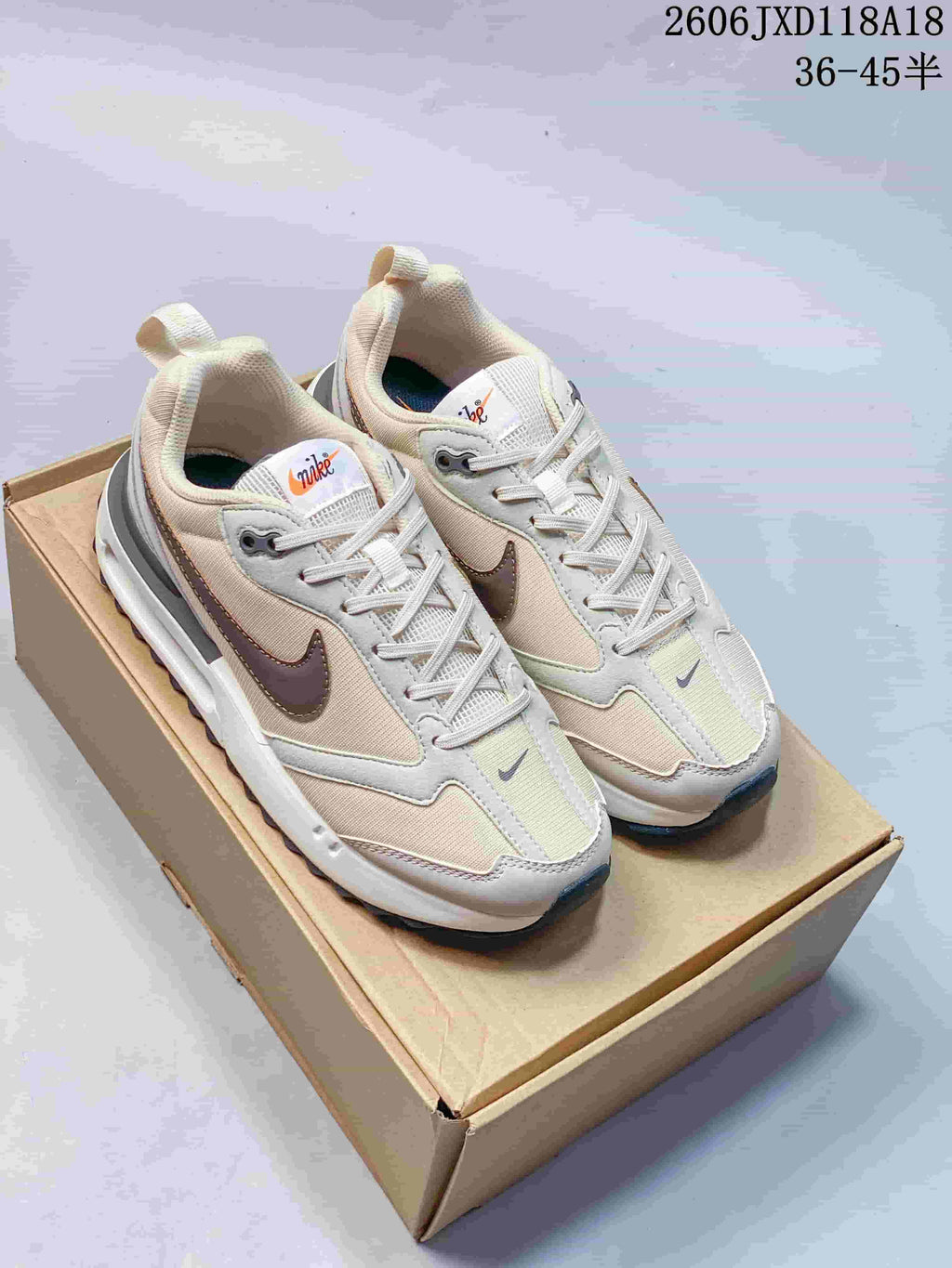Pair of light neutral Nike Air Max Dawn sneakers on a box, shown from above