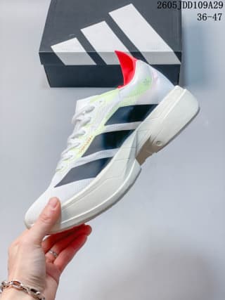 Side view of the Adidas running shoe showing black side stripes, red heel detail, and sculpted sole.