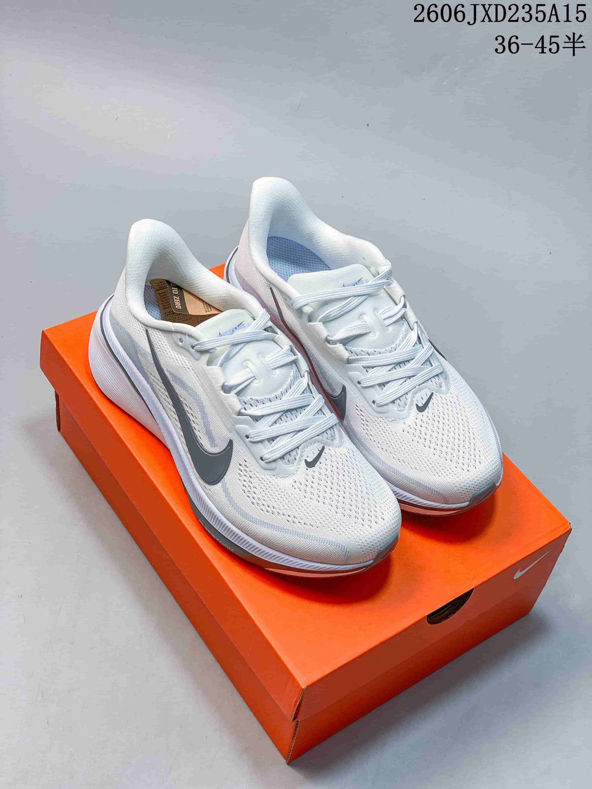 Pair of white and grey Nike Pegasus 42 running shoes on an orange shoebox