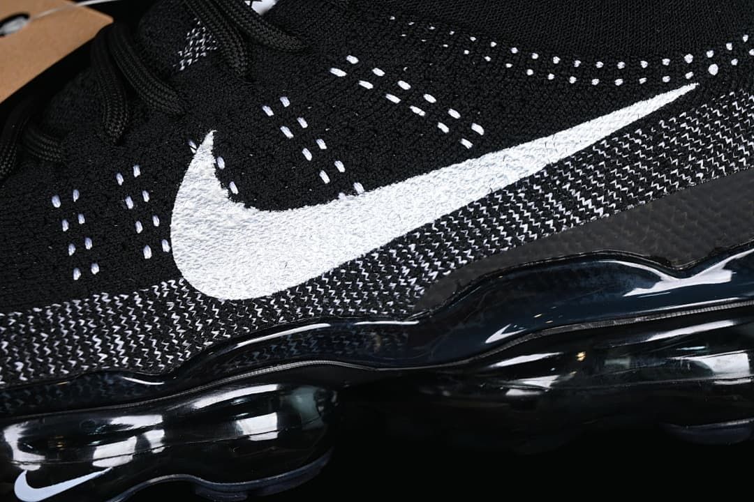Close-up of the white Swoosh and patterned black knit upper