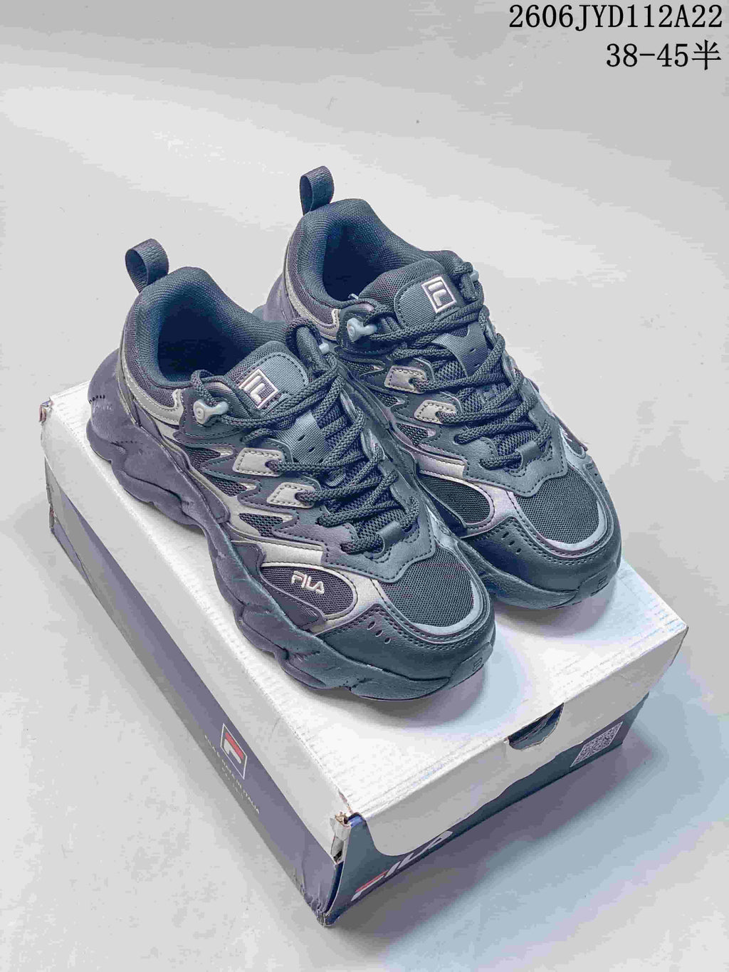 Pair of gray FILA Fusion Arceus sneakers on a shoebox