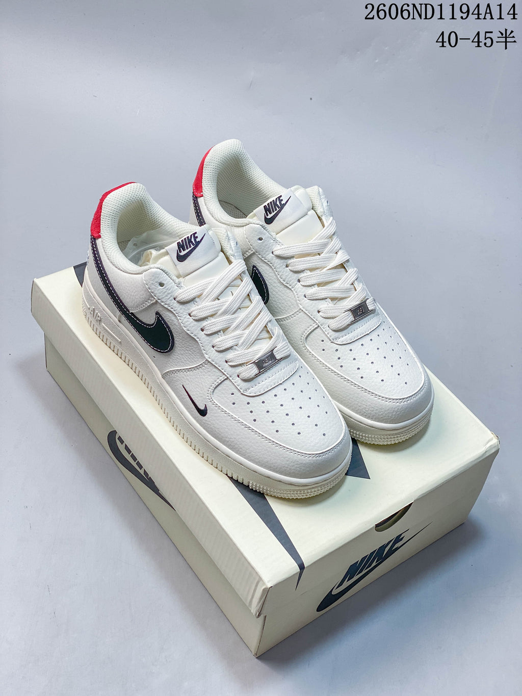 White Nike Air Force 1 '07 Low sneakers with dark contrasting accents, photographed on a shoebox.