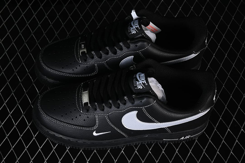 Pair of black low-top sneakers with white accents, viewed from above
