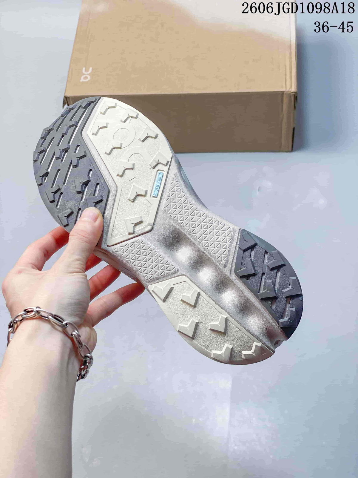 Underside of a sneaker showing a patterned outsole with light and dark sections.