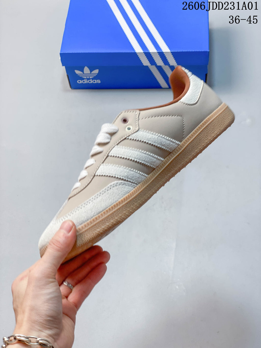 Side view showing the white stripes and gum-colored sole of an Adidas Samba OG sneaker