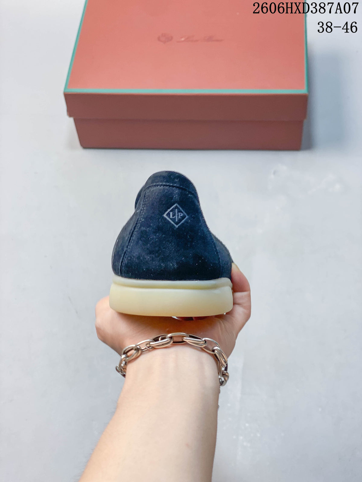 Rear view of a navy loafer with a small heel emblem