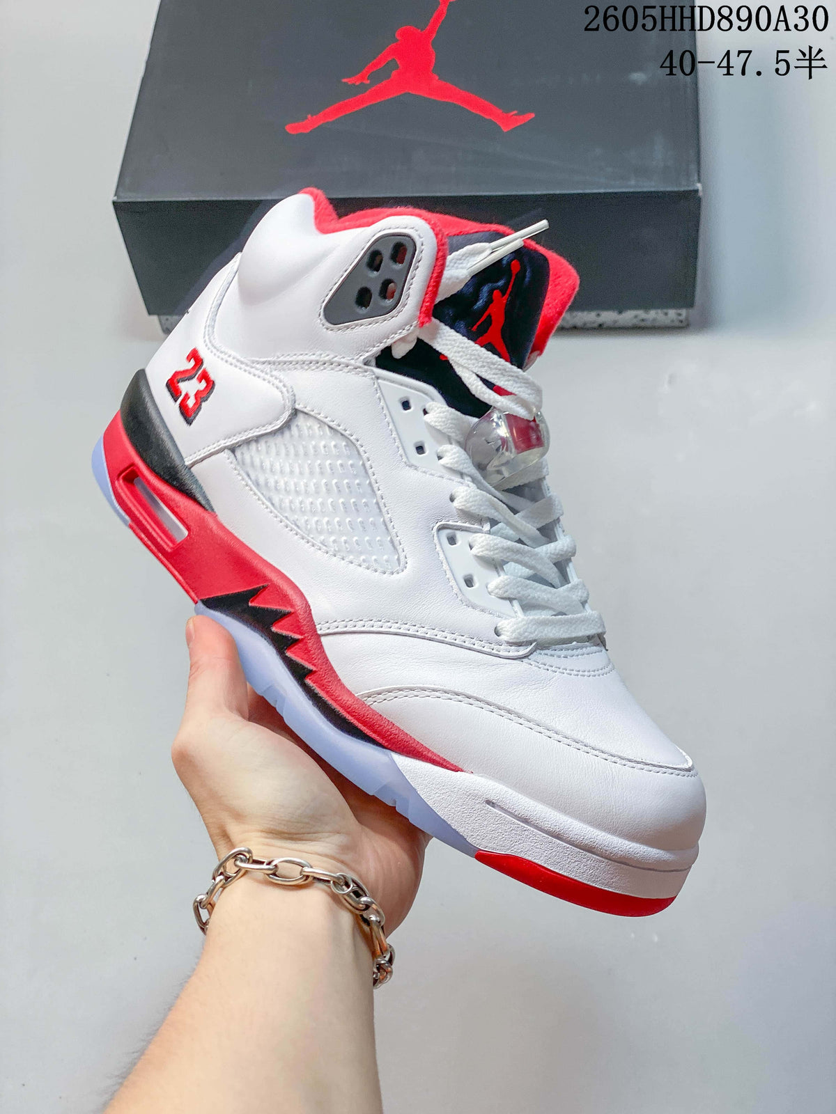 Side view of the white high-top sneaker with red and dark details