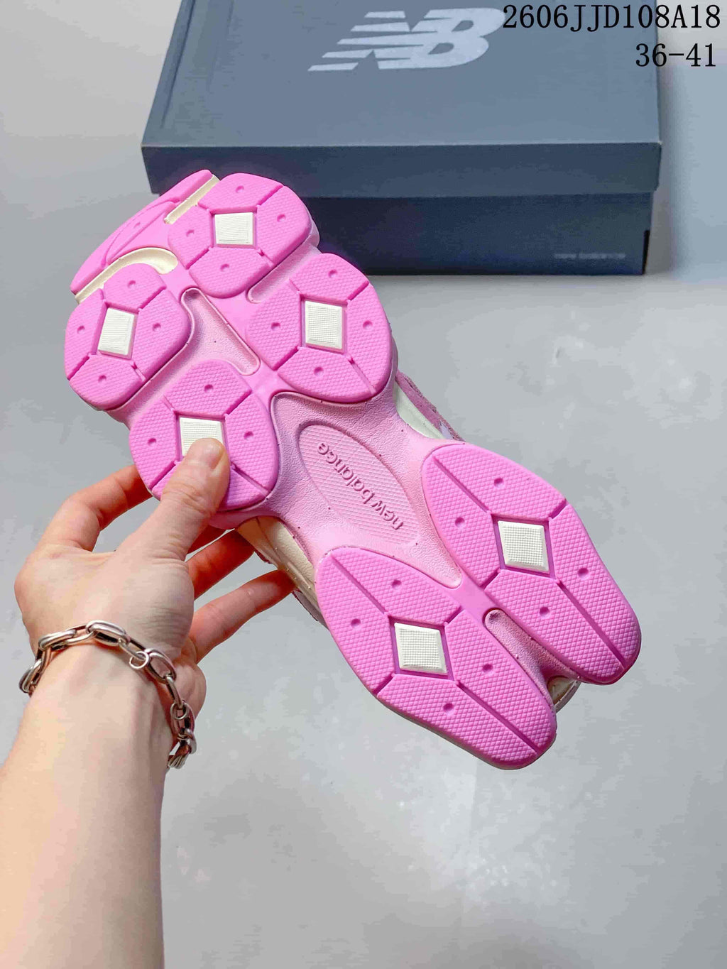 Underside of a pink sneaker showing its segmented outsole