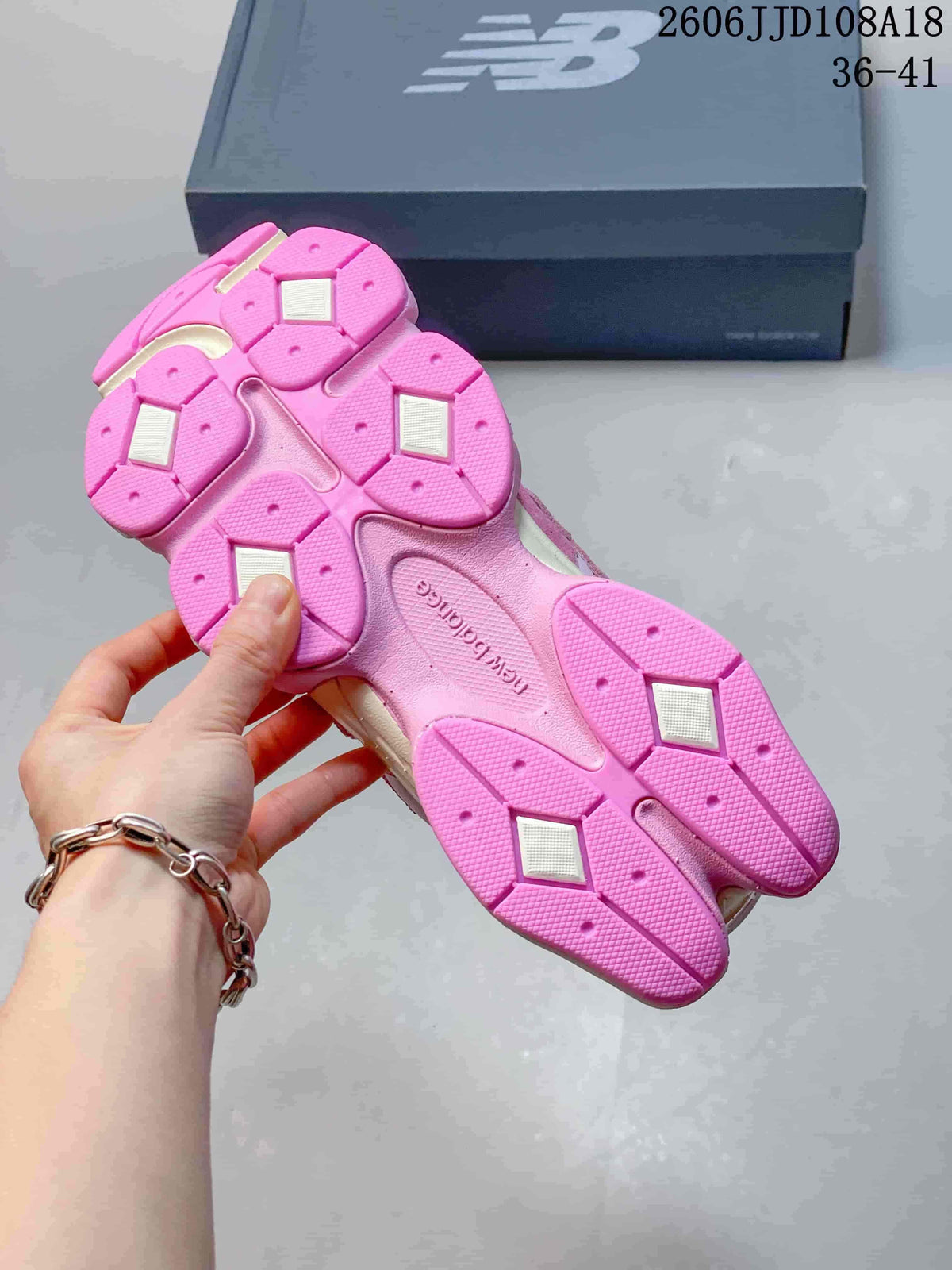 Underside of a pink sneaker showing its segmented outsole