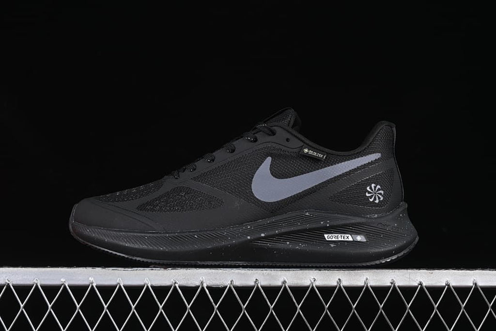 Side view of black Nike Zoom Winflo 7 shoes with a light gray Swoosh and speckled midsole.