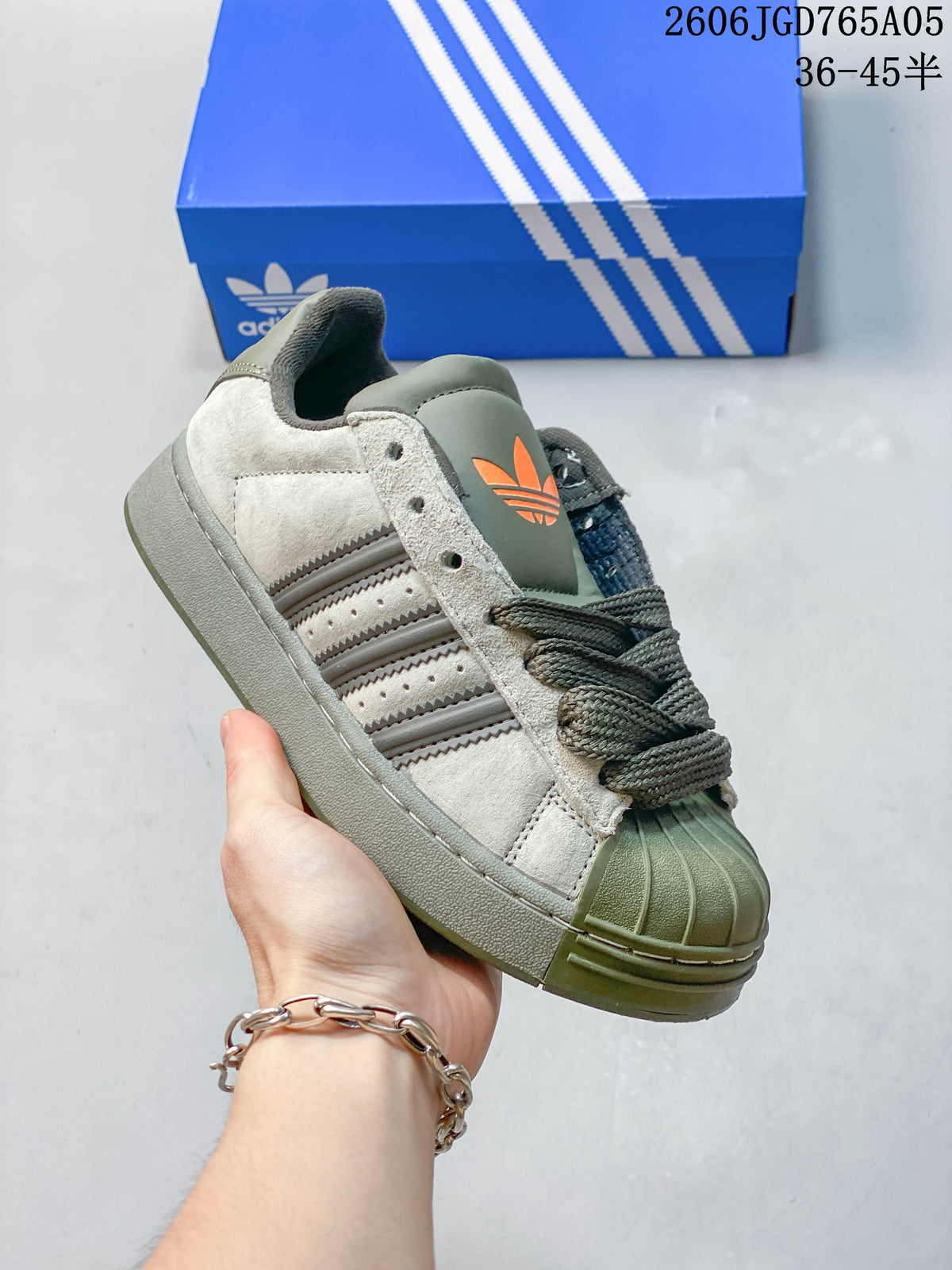 Side view of a grey Adidas Originals Superstar XLG sneaker showing its shell toe, three stripes and chunky sole.